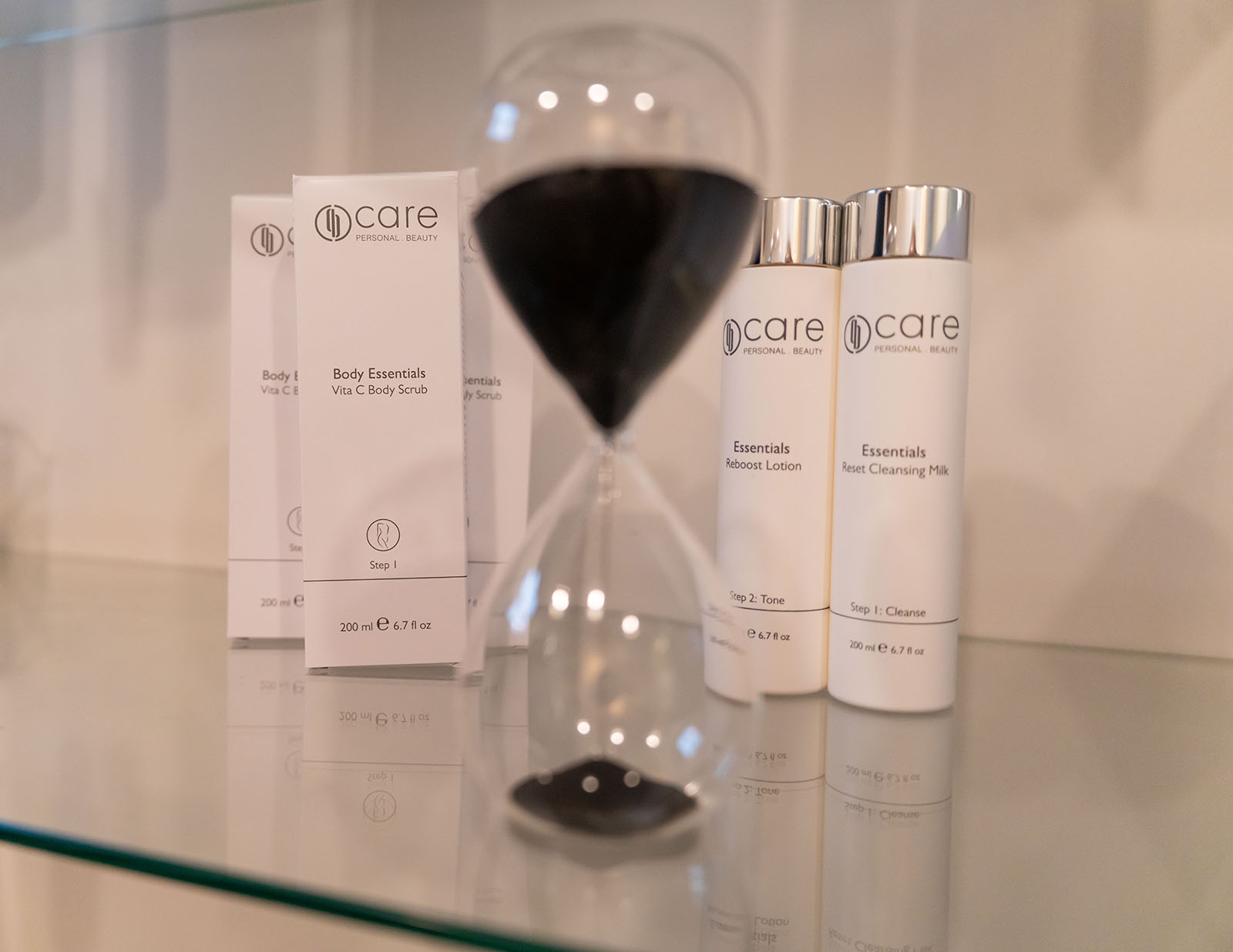 Producten voor huidverbetering met een zandloper in de voorgrond